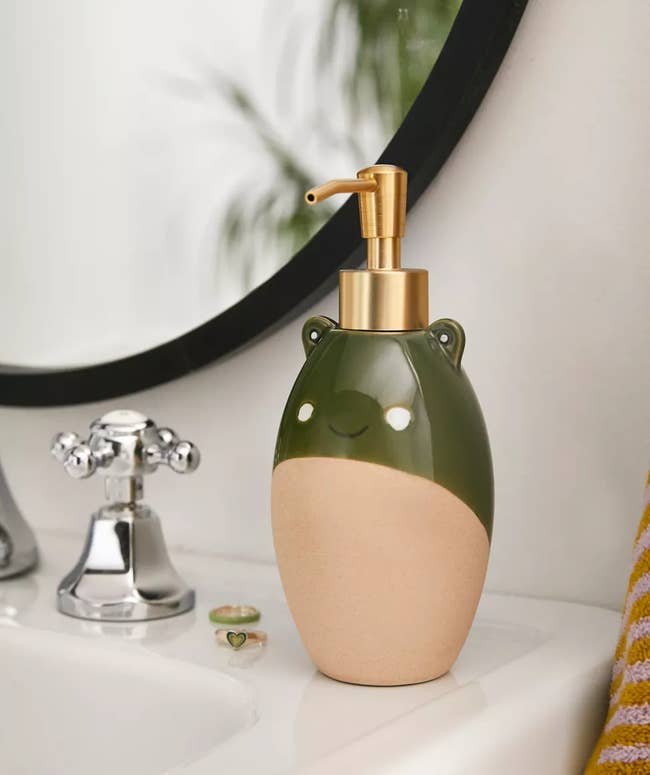 ceramic soap dispenser with green frog face and gold tone pump