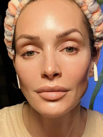 Person wearing wireless earbuds and a towel headband, with a focus on skincare and clear skin, possibly promoting beauty or skincare products