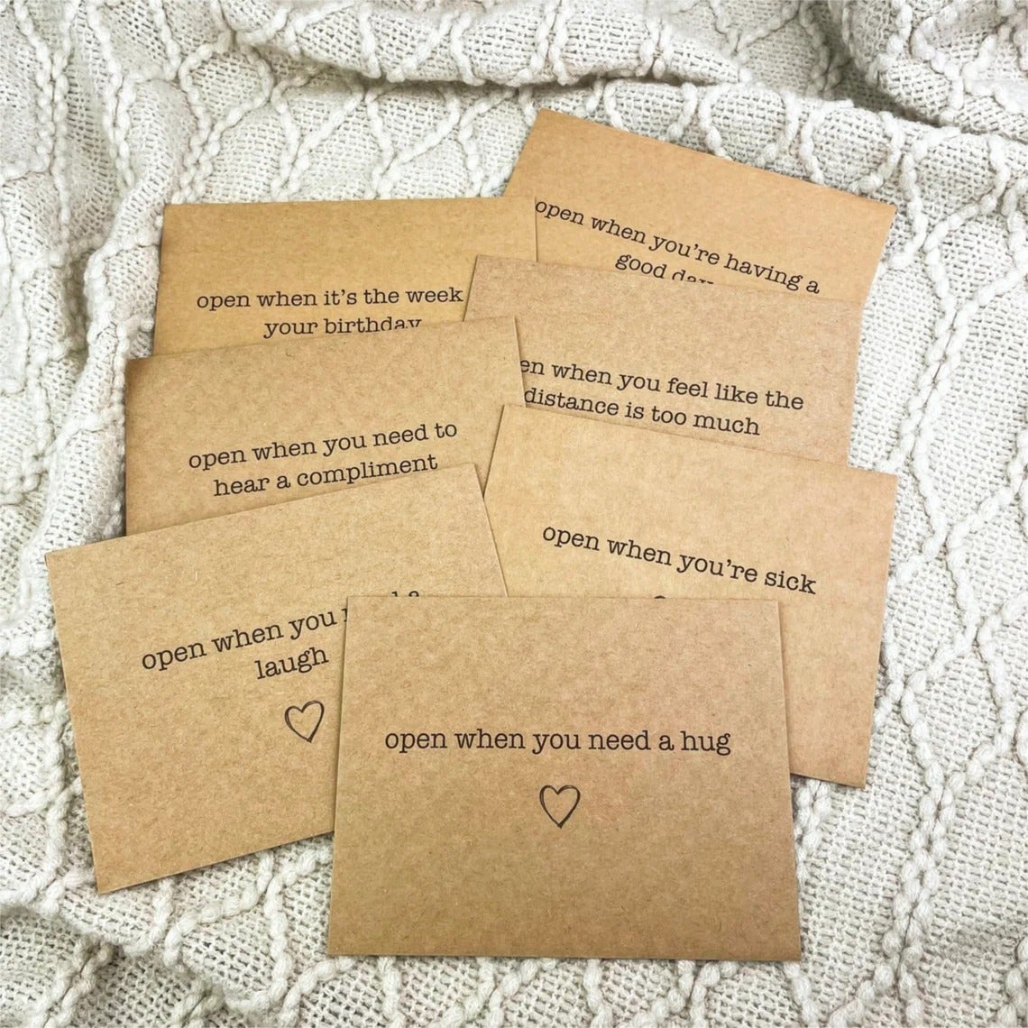 seven cards in brown envelopes with messages that say 