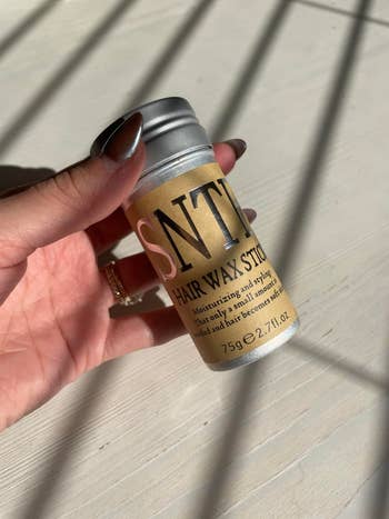 Hand holding a tiny  vessel  labeled 