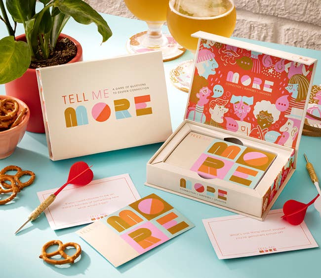 Tell Me More game opened to show whimsical drawings inside, with a few cards taken out to show their size and design