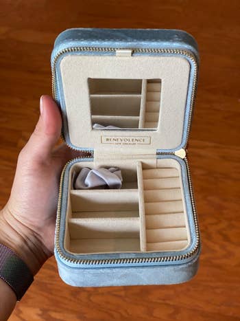 Hand holding a velvet jewelry container