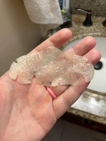 Social media trends Viral content Trending hashtags Social media updates Trending memes and videos reviewer holding a translucent nose strip,  showing blackhead removal, above a bathroom sink