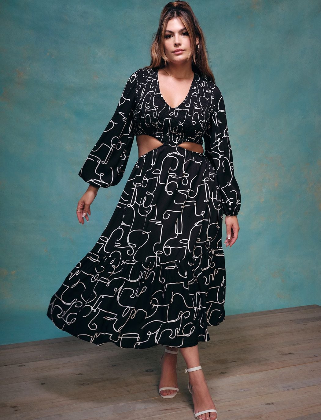 a model wearing the dress in black with white designs