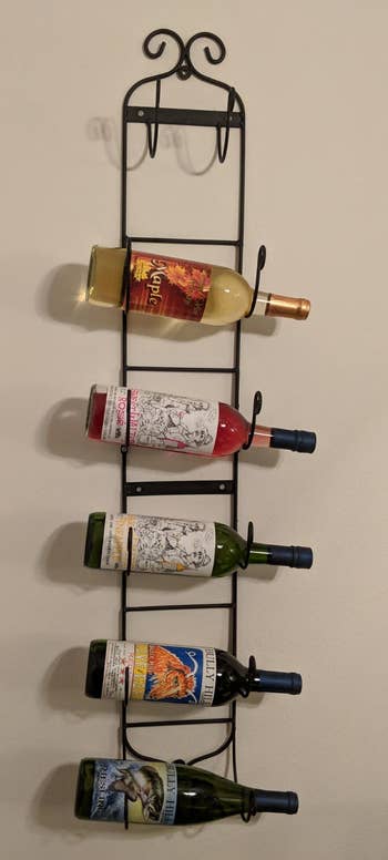 Reviewer image of one of the black wine racks with five bottles on the wall