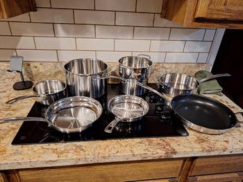 A assortment of stainless alloy and nonstick cookware, including pots and pans, displayed connected a room stovetop. Perfect for location cooking needs
