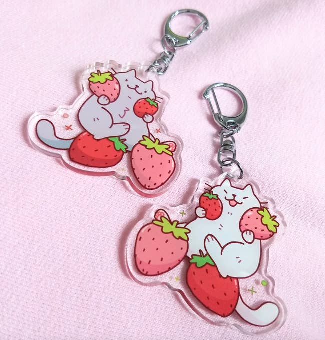 keychains of a cats holding strawberries 