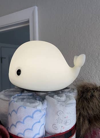 The small whale nightlight on top of some towels 