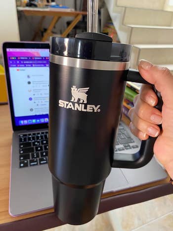 image of reviewer holding up their black Stanley tumbler