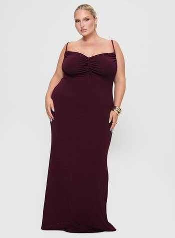 model in a sleek, elegant maroon dress with thin straps and a subtle neckline