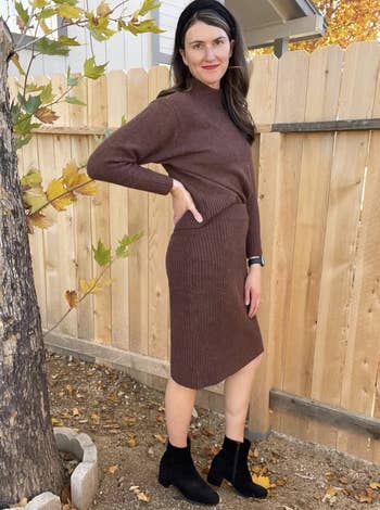 reviewer wearing the skirt and sweater set in brown