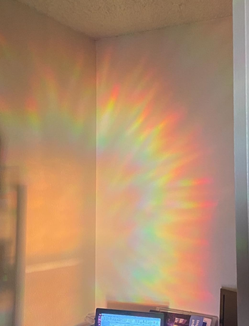 a rainbow cast across a wall above a desk