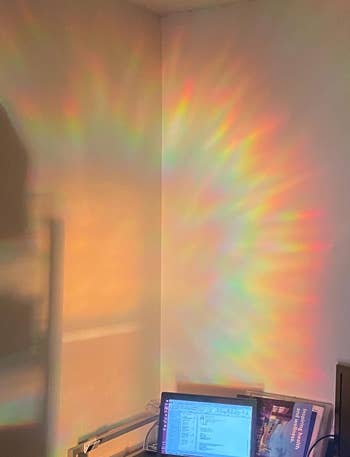 a rainbow cast across a wall above a desk