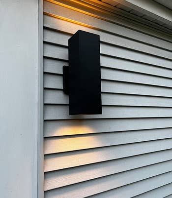 reviewer's black sconce mounted on the outer wall of a house