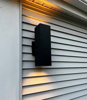 reviewer image of a black sconce mounted on the outer wall of a house