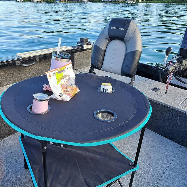 Boat table with snacks and a drink near a seat, overlooking water. Ideal for a relaxing shopping reference for boat accessories
