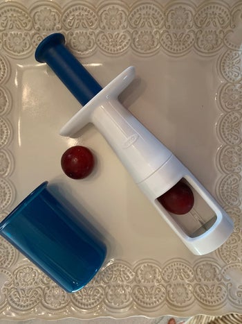 reviewer image of the grape cutter and a grape