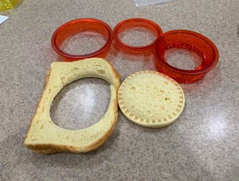 the two slices of bread pressed together and cut into a crustless circle sandwich