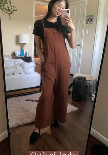 reviewer wearing the brown jumpsuit over a black top