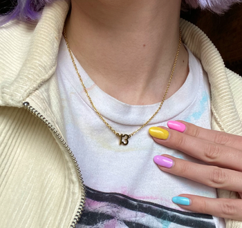 photo of the shop owner wearing a gold 13 necklace