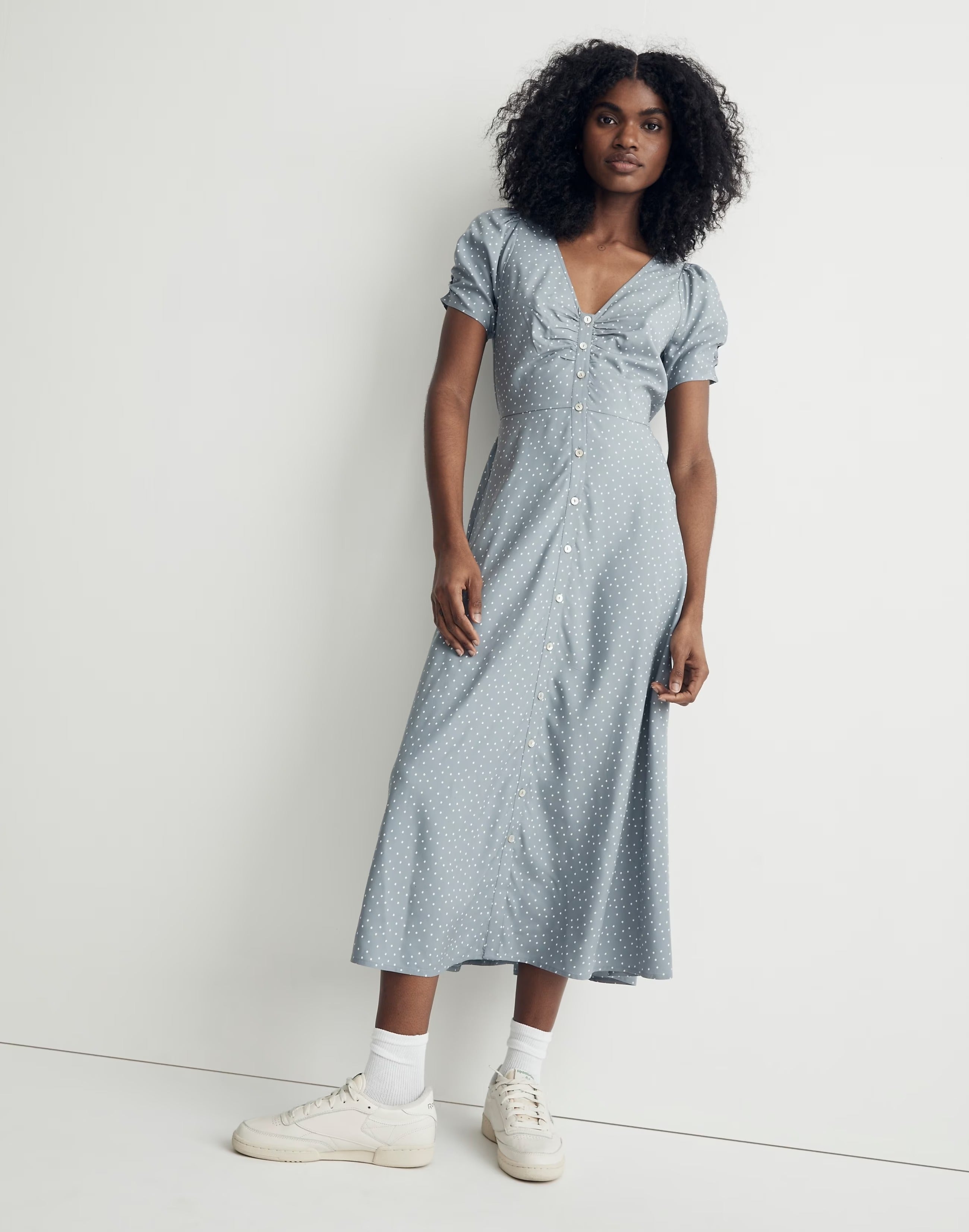 model in blue gray short sleeve button down midi dress with white dots