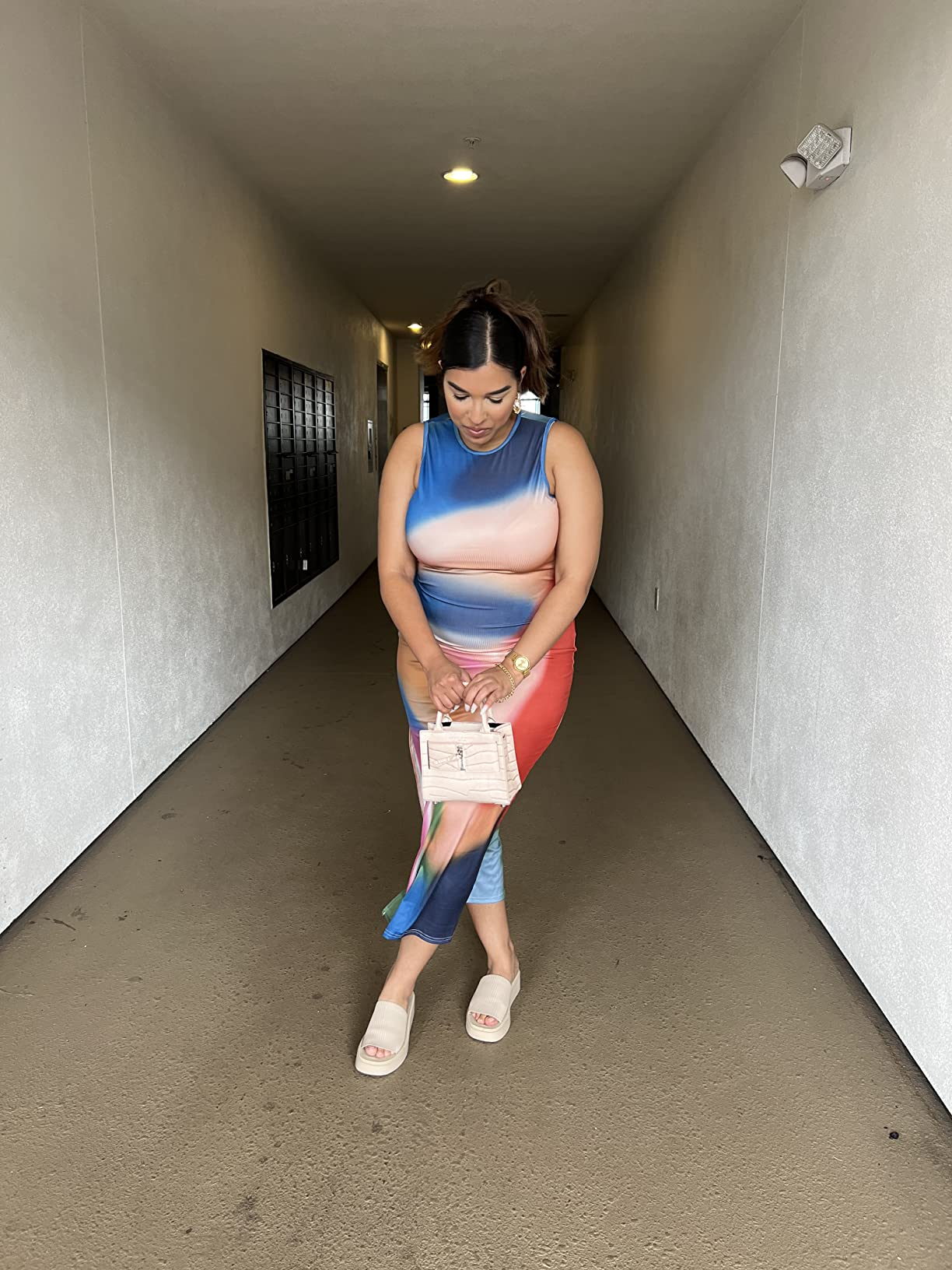 Person successful  a sleek, fitted formal  and sandals holding a tiny  handbag, lasting  successful  a hallway