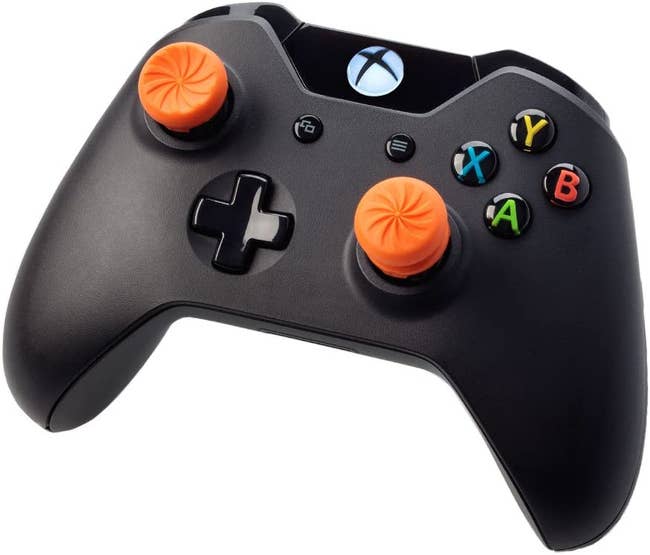 two orange rubberized attachments to the thumbsticks on an xbox controller