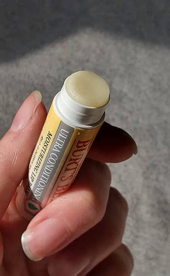 reviewer holding the lip balm