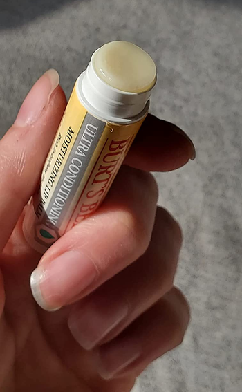 reviewer holding the lip balm