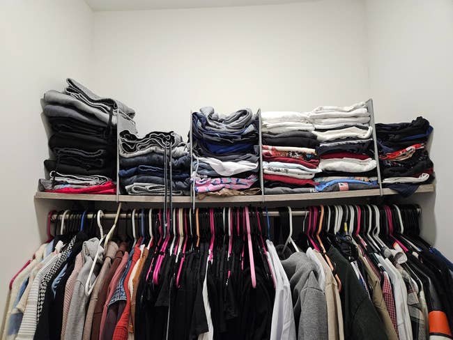 Neatly organized closet with folded apparel  connected  shelves and shirts hanging beneath  connected  hangers