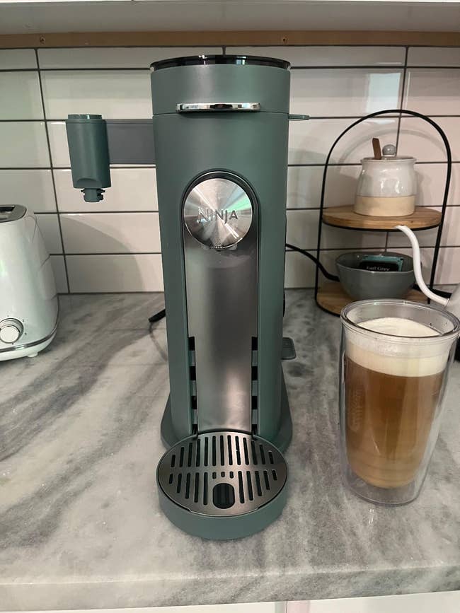 Coffee instrumentality connected a room antagonistic with a solid of frothy latte adjacent, surrounded by room decor and appliances