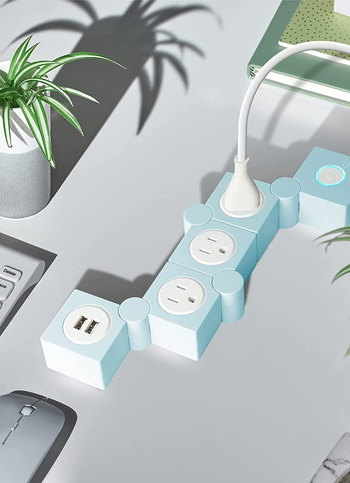 swivel outlet with three standard plugs, two for usb, and a power button. all on separate squares. 