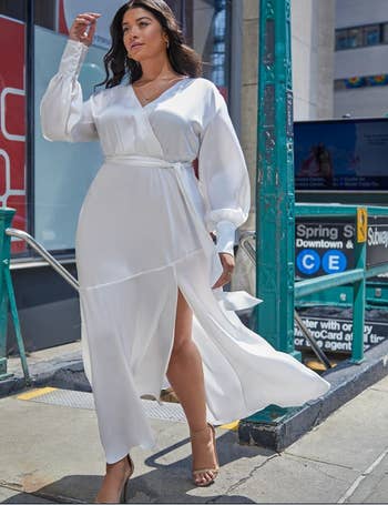 model coming out of the subway wearing white satin maxi dress
