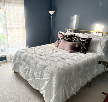 reviewer photo of the gold metal bed frame in bedroom