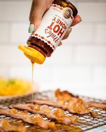 Reviewer pouring hot honey on bacon