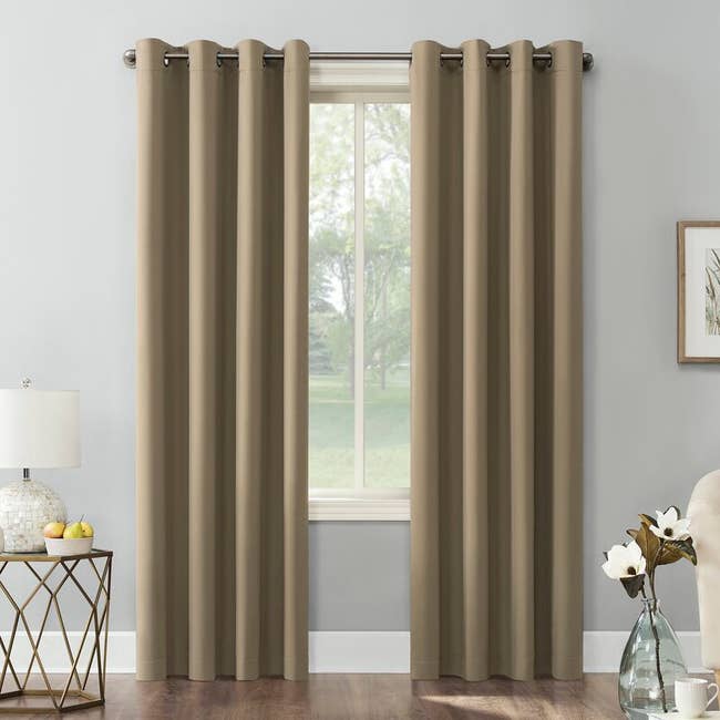 A set of beige of blackout curtain hung up