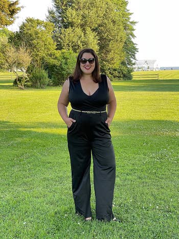 reviewer wearing black jumpsuit with gold belt
