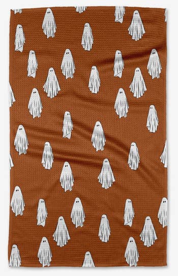 a brown tea towel with white ghosts on it