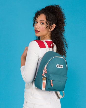 a model wearing a small blue backpack