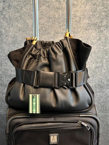 reviewers bag strapped to their suitcase with Cincha belt