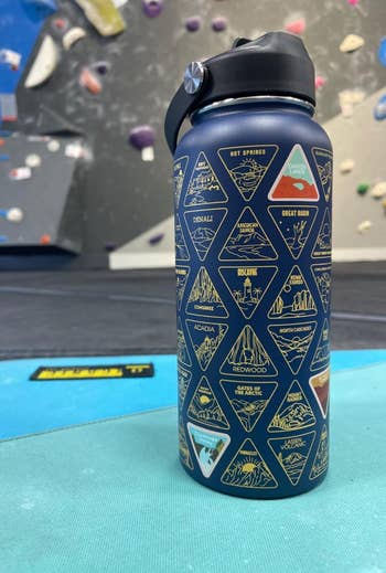 Water vessel with nationalist parkland logos and names, acceptable connected a gym level with climbing holds successful the background
