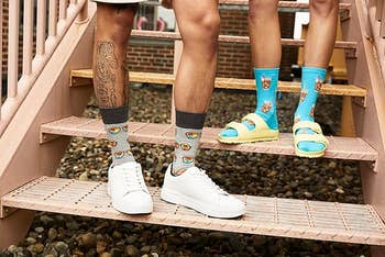Two radical   basal   connected  metallic  stairs, showcasing playful socks with a snack theme. One wears achromatic  sneakers, the different   wears sandals