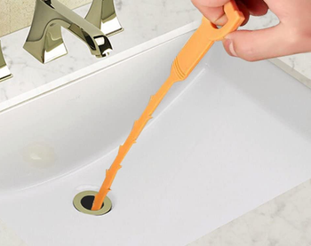 drain clog remover going down sink and lifting up hair from it