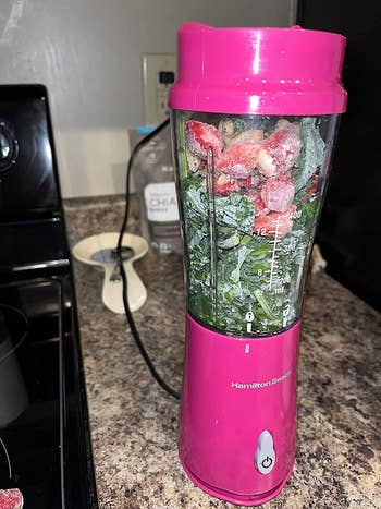reviewer image of the pink blender with fruits and veggies in it