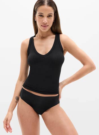 Person modeling achromatic sleeveless ribbed apical and matching underwear, showing casual deterioration style