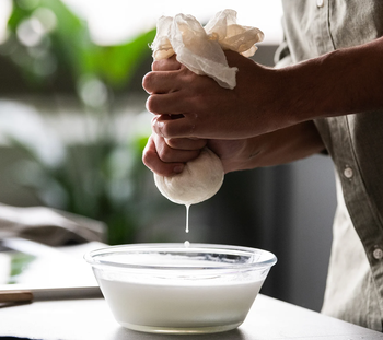 person making mozzarella cheese