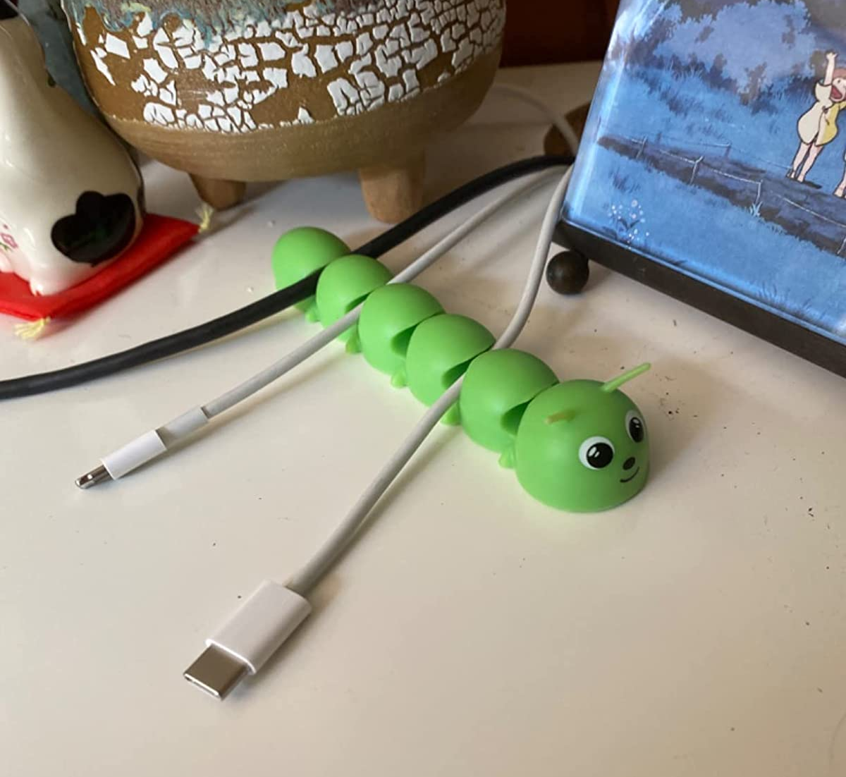 Reviewer's caterpillar cord organizer on their desk holding their cables securely
