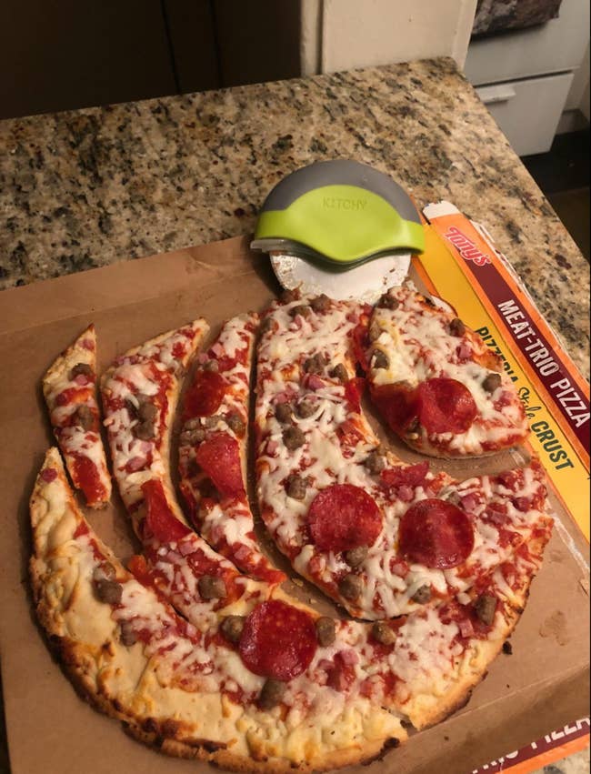 A pizza cut into odd shapes using a pizza wheel 
