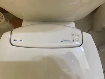 close up reviewer image of the heat settings on the toilet seat