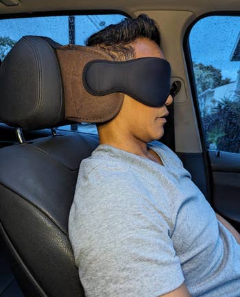 reviewer wearing a sleep mask resting in a car seat